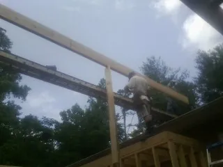 Carpenter setting a ridge beam over a new addition frame — Ice Dam Removal by Roofing Brothers in Paynesville