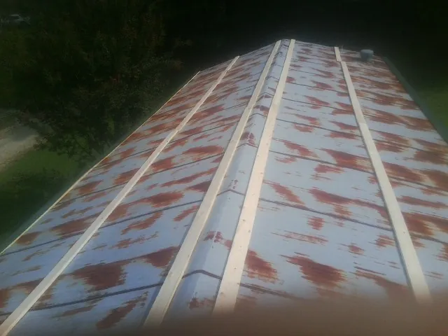 Rusted metal roof panels with new wood purlins before replacement — Storm Damage Roof Repair in Paynesville by Roofing Brothers
