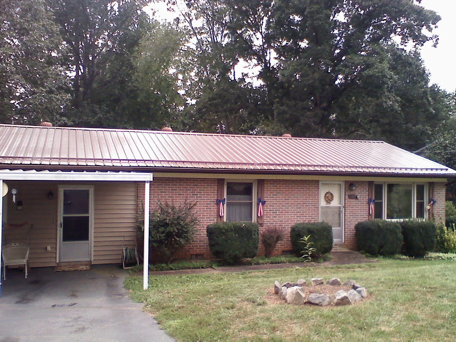 Bronze metal roof and carport on a brick ranch home — Roof Repair work by our crew in Paynesville